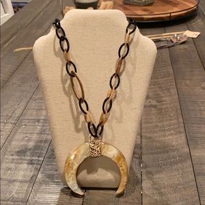 Long necklace with horseshoe accent.